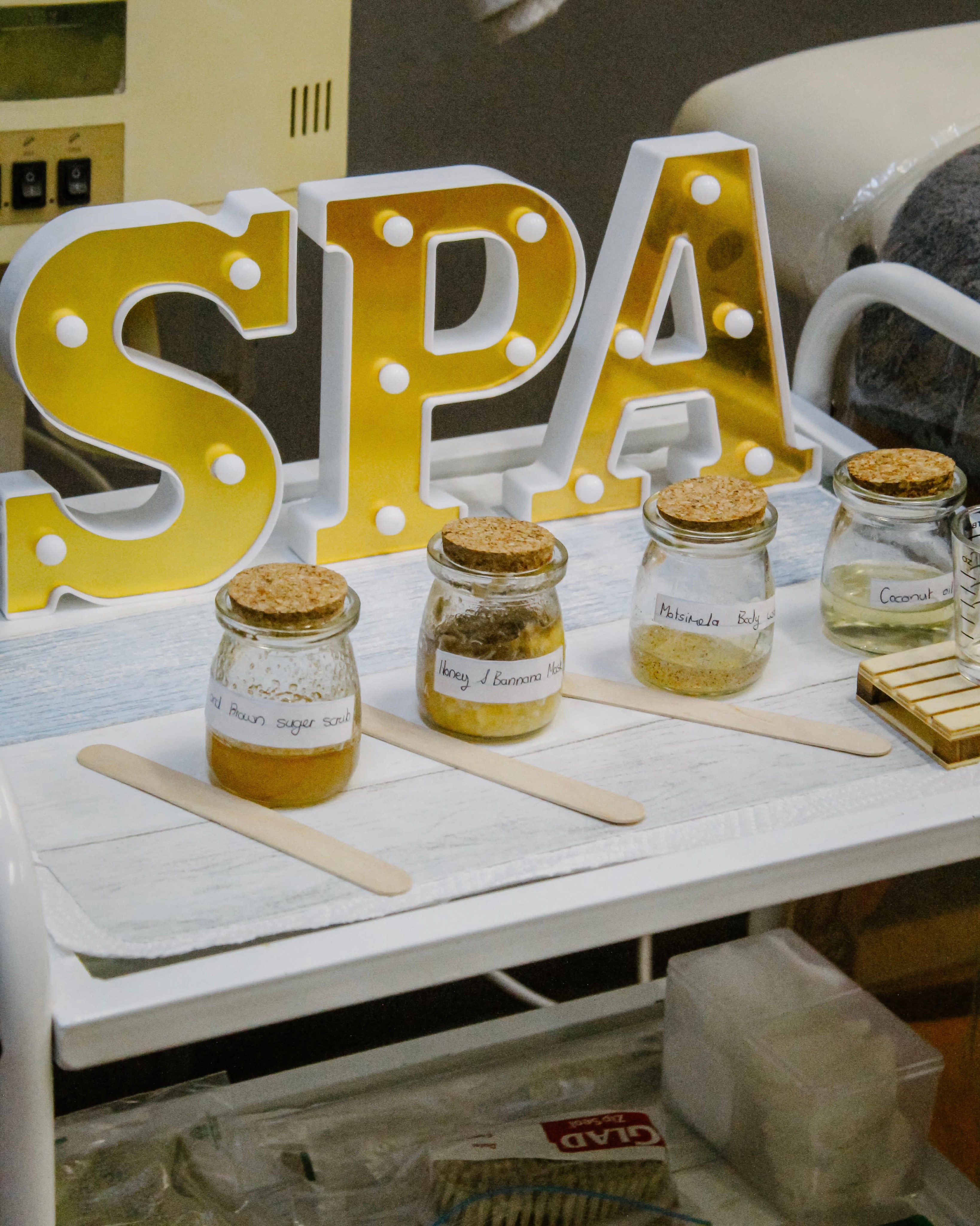 Handmade spa products with SPA marquee sign at the school