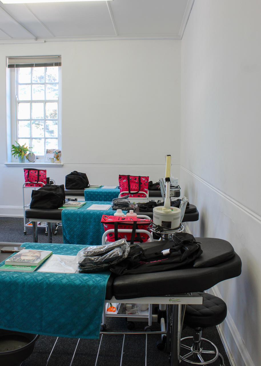 Beauty training room with treatment beds and student kits