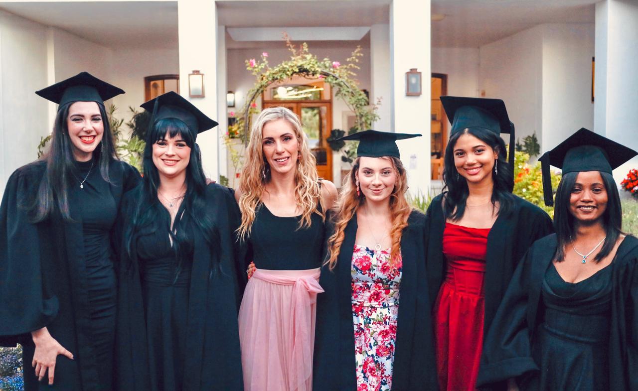 Graduates posing with the principal at Helderberg School of Beauty graduation ceremony