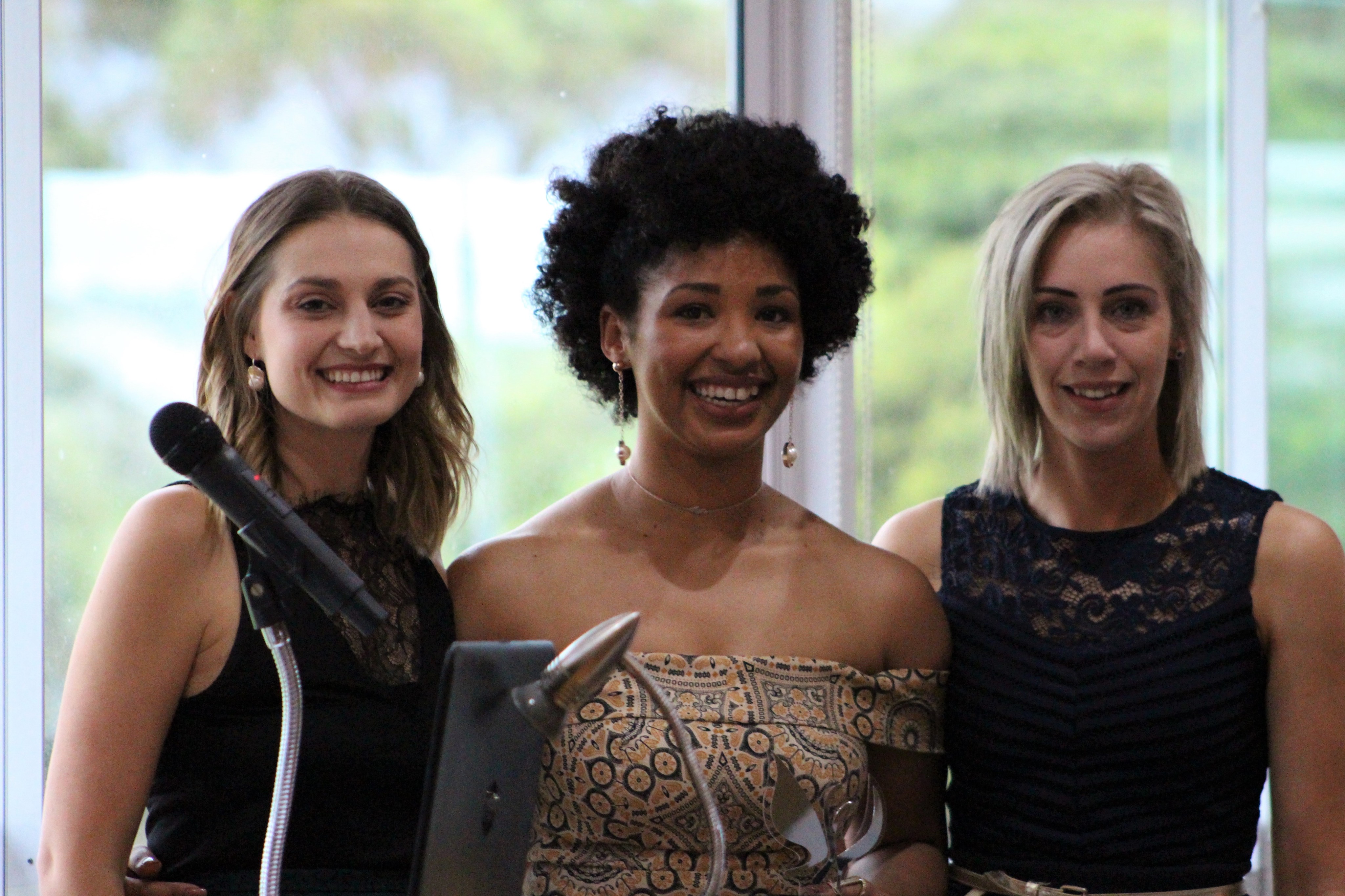 Three women smiling at a school event