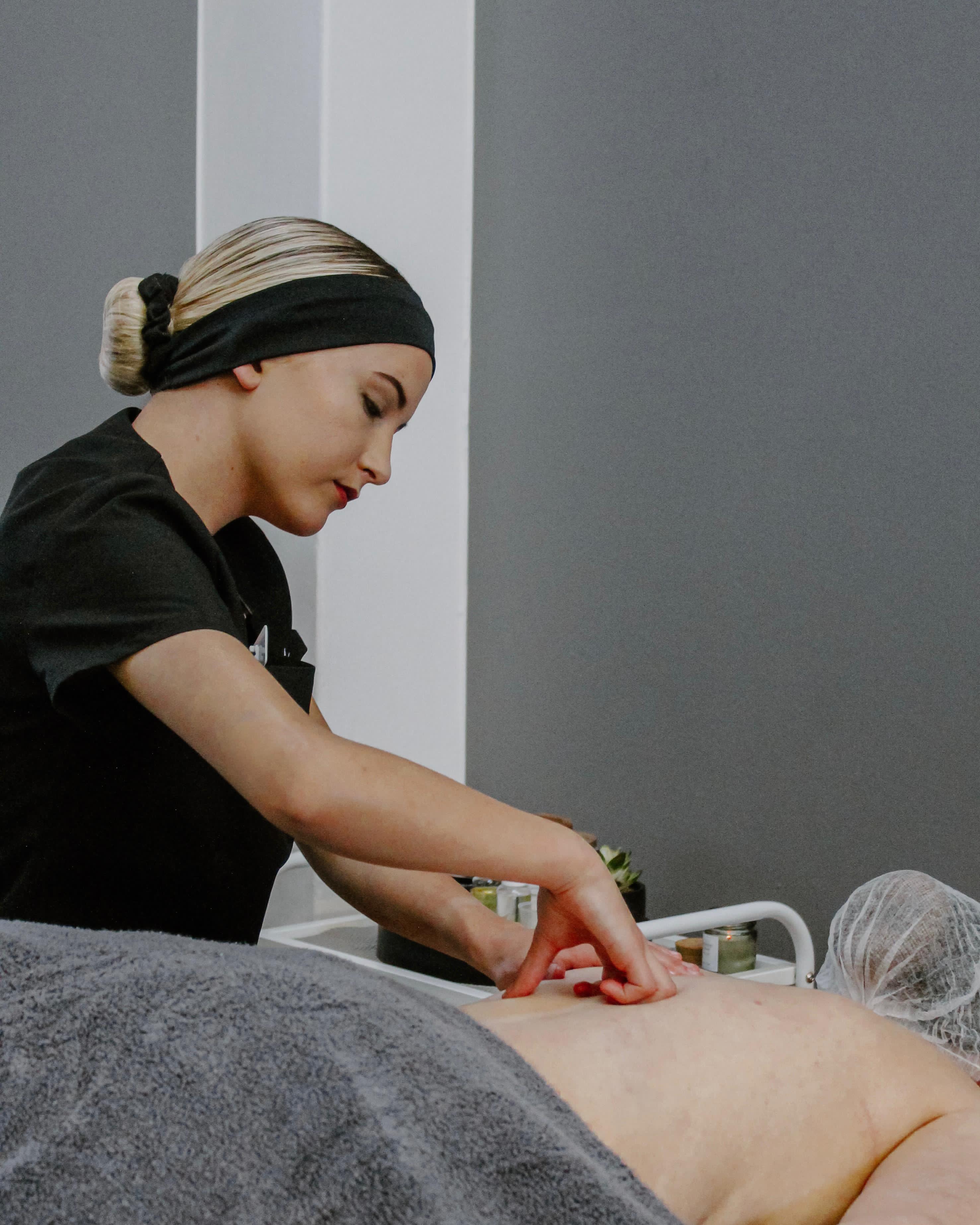 Student performing a back massage treatment in the salon