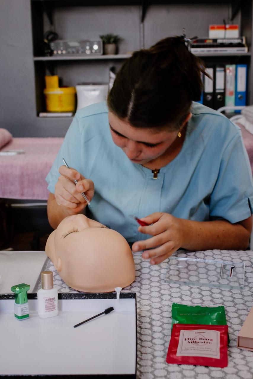 Student practising lash extensions on a mannequin head