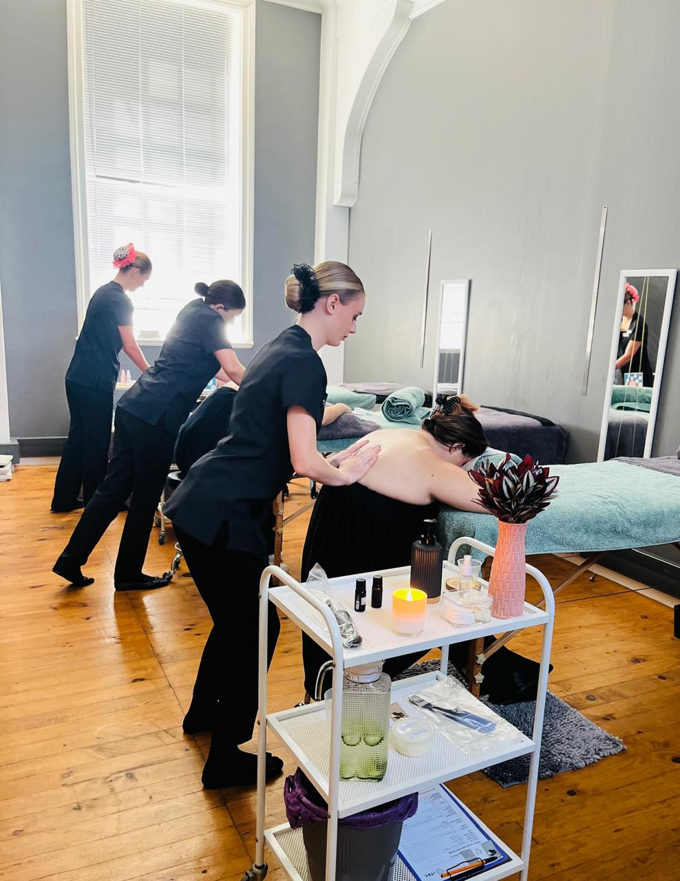 Students practising massage techniques in the training salon