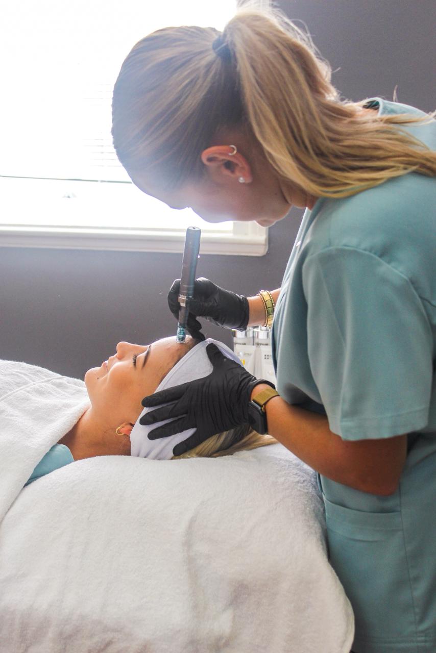 Student performing a microneedling facial treatment